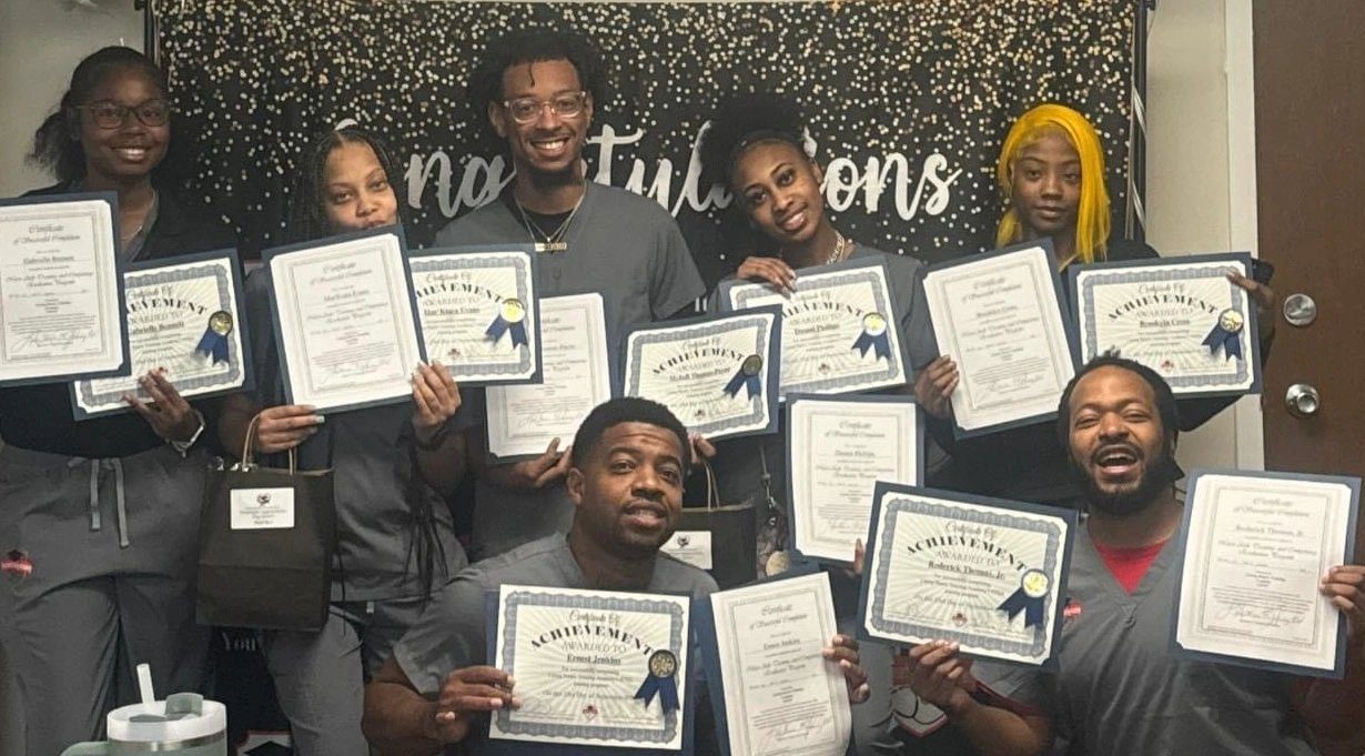 Graduates holding their certificates up together at the end of a class